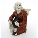 An early 19thC Staffordshire pearlware Nightwatchman toby jug, depicting a seated wigged night