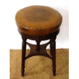 A Victorian mahogany adjustable height piano stool with circular leather upholstered seat and