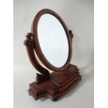 A Victorian walnut toilet mirror with cushion moulded oval mirror and trinket section . Approx 21