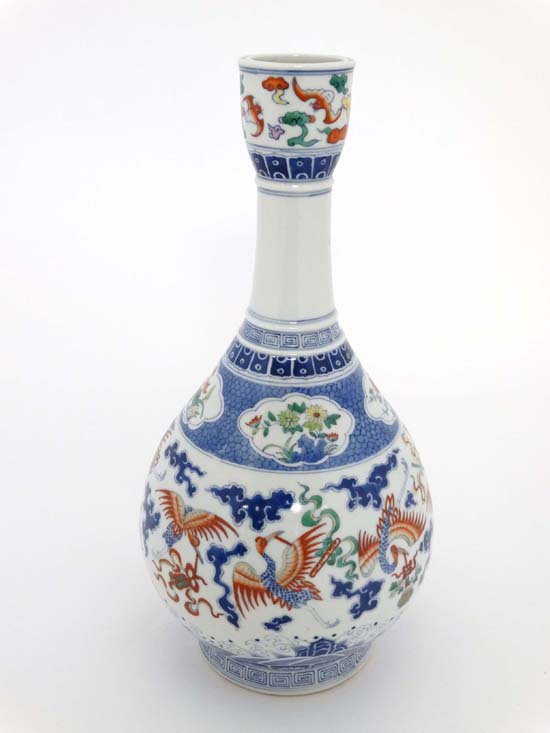 A Chinese porcelain bottle vase decorated with cranes in flight, bats and precious objects in blue
