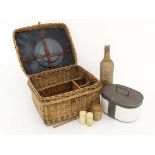 An early 20thC Continental wicker picnic basket comprising a ceramic food container, bottle,