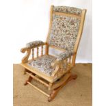 An American stripped walnut and upholstered late 19thC rocking chair with upholstered back splat,