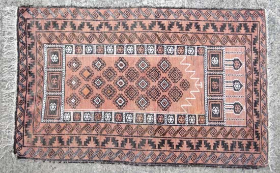 Rug carpet : An Afghan rug, the rose madder mehrab with an overall design of guls, stylised