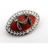 An Edwardian white metal brooch of elliptical form with red and white enamel and paste stone