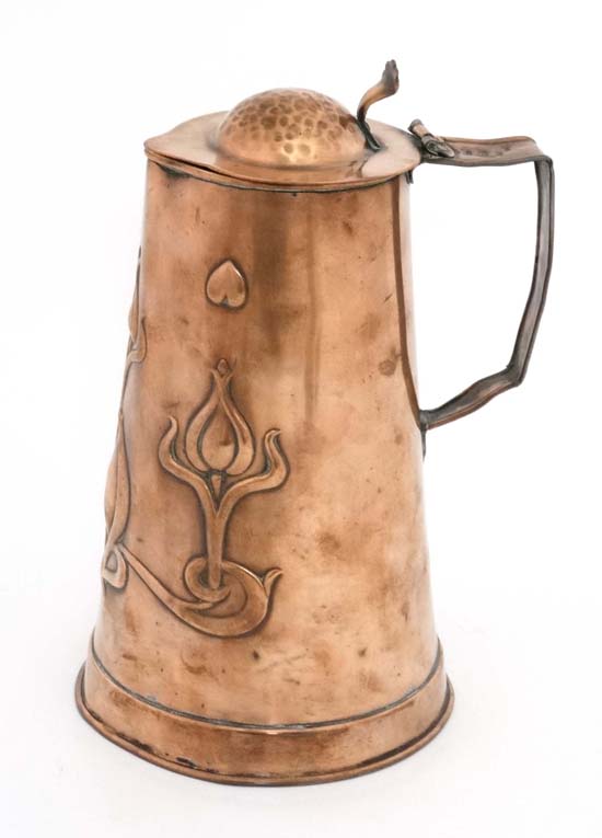 Art Nouveau : A copper hinged lidded bear tankard jug with embossed decoration with heart, tulip