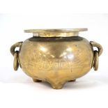 A large Oriental tripod brass censor with ring handles and hammered decoration depicting deer and