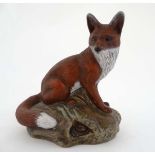 A Poole stoneware figurine of a fox sitting on rabbit holes designed by Barbera Linley-Adams.