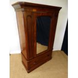 A Victorian mahogany single wardrobe with mirrored door over single drawer  opening to reveal