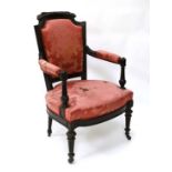 A Louis XV ebonised rosewood open armchair with upholstered back support, arms and overstuffed seat.