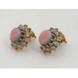 A pair of 9ct gold stud earrings set with central opals boarded by white stones in a cluster setting