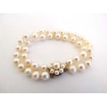 A 2-strand pearl bracelet with 18ct gold clasp and safety chain and having further pearls to