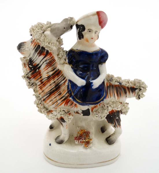 A Victorian Staffordshire figure group depicting one of Victoria's children seated on a goat.