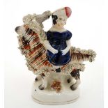 A Victorian Staffordshire figure group depicting one of Victoria's children seated on a goat.