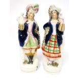 A Pair of Victorian Staffordshire figures depicting a male and female wearing highland dress and