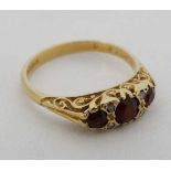 An 18ct gold ring set with 3 graduated garnets CONDITION: Please Note -  we do not make reference to