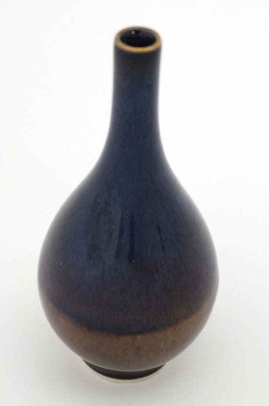 An Oriental signed vase of bottle shape with high fired two coloured glazes, with four character