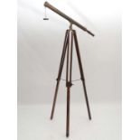 A c.1900 brass telescope with end cap and adjustable focus  mounted upon an adjustable brass and