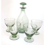 Whitefriars : A green tinged glass decanter with 4 pedestal glasses having ribbed decoration .