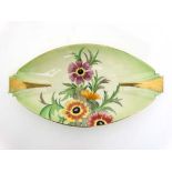 An Art Deco Carltonware oval shaped dish painted with anemones on a washed green ground and having