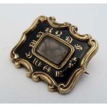 Mourning / Memorial jewellery : A Victorian gold brooch with black enamel decoration  with central