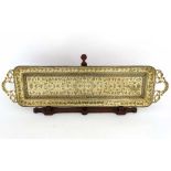 An Indian Benares? long two handled tray with black decoration on a wooden stand 35 3/4" long x 9
