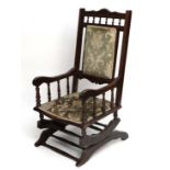 An early 20thC American stained wood upholstered rocking chair  with over stuffed seat and back