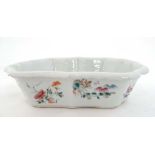 An Oriental shaped dish with hand painted enameled decoration depicting various flowers and