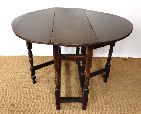 A  c.1700 medium to small sized oak oval drop flap table with twin gate legs 37 1/2" wide