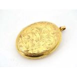 A 9ct gold large oval locket with engraved acanthus scroll decoration 2" long  CONDITION: Please