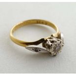 An 18ct gold ring with central diamond with further diamond set to each shoulder (4g) CONDITION: