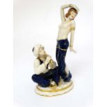 A Royal Dux Art Deco figure group depicting a half naked female in exotic dance pose while a