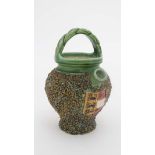 A small teapot / jug with applied decorative gravel to body. Armorial plaque to front depicting 3