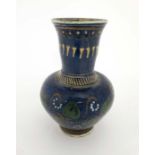 A large pottery vase decorated with slip glazes with stylised heart shaped scrolling leaves and