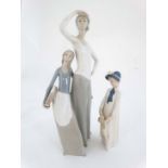 A Rex figure of a girl carrying a doll . Marked to base. 9 '' high. Together with a Nao figure group