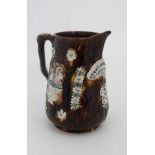 A 19thC Bargeware / Measham jug decorated in traditional manner having a white arched plaque