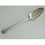 A Geo III Old English pattern dessert spoon with engraved bright cut decoration to handles.