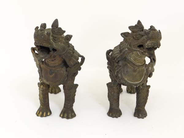 A pair of bronze Vyala, Nepal , 19th / 20th century, Their fanged mouths open, the bodies with swirl