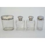 4 glass dressing table bottles with silver tops. Hallmarked London 1917 maker Walker & Hall . The