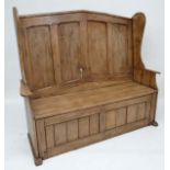 An 18thC Artisan made panelled settle with four panel back, shaped wings and arms. Approx 61" wide x
