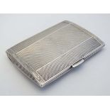 An Art Deco silver cigarette case with engine turned decoration and gilded interior. Hallmarked