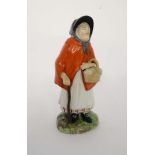 A Victorian Staffordshire figure depicting an elderly female wearing red cloak, tied bonnet and