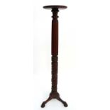 A 19thC mahogany circular torcheir with gadrooned and carved column and tri form ball and claw