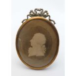 An early 19thC brass miniature easel frame with ribbon cresting  having a Georgian silhouette of a