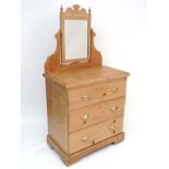 A late Victorian stripped pine dressing chest comprising mirror over three graduated long