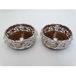 A pair of silver plate decanter/ bottle coasters with ornate cast fruiting vine decoration and