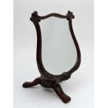 An early 19thC  mahogany adjustable height tripod shaving stand, the mirror formed as a lyre .