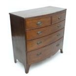 A Regency mahogany bow front of chest of drawers having 2 short over 3 graduated long drawers on