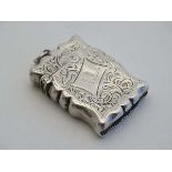 A silver vesta case of shaped form with engraved acanthus scroll decoration with hinged lid and