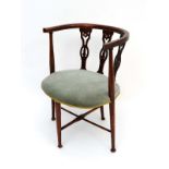 A c.1900  mahogany oval chair with with inlaid stringing and applied floral decoration to the