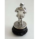 A Continental white metal model of a man carrying a duck etc on a wooden base. The whole 3 1/4" high